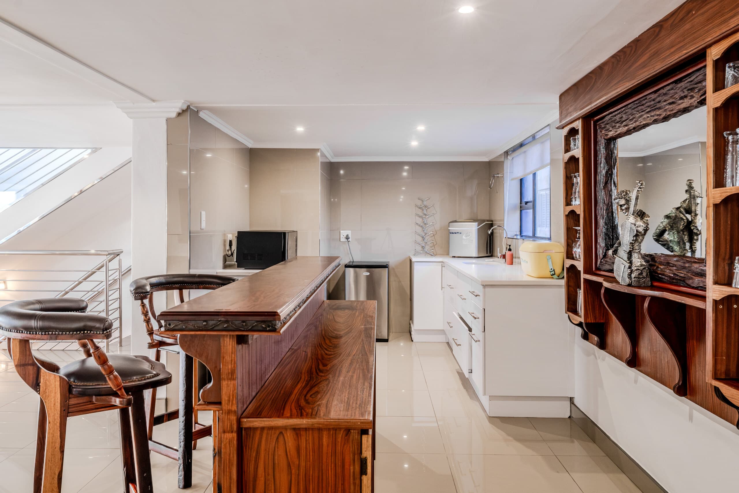 Timber bar counter and stools beside the kitchen
