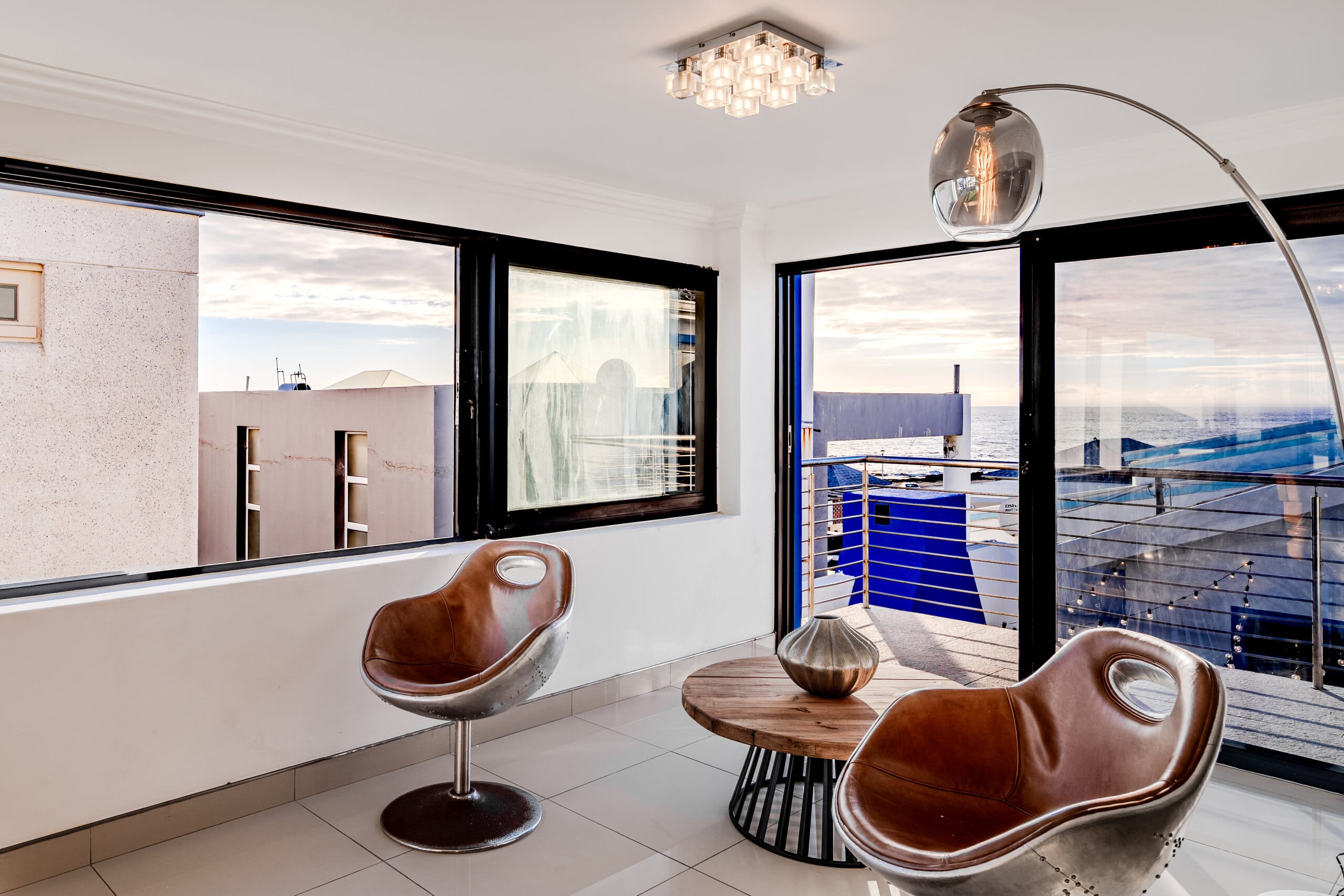 The glass dining box at The Lighthouse with tan swivel chairs facing the Atlantic