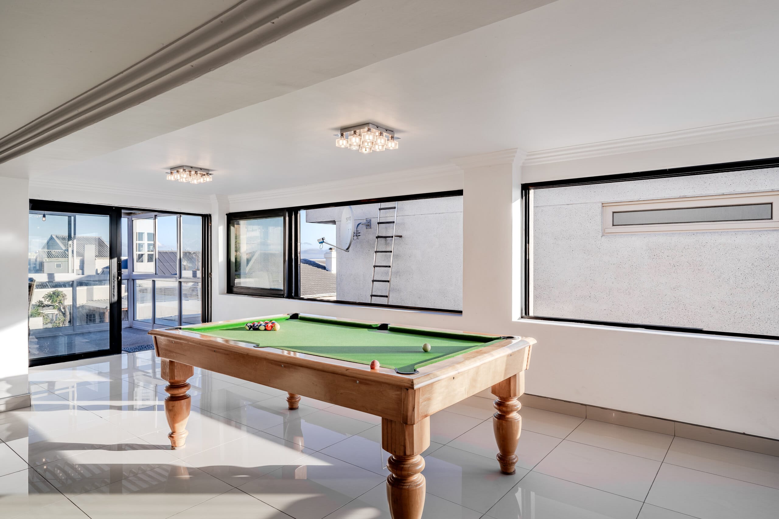A room devoted to play at The Lighthouse, with a pool table and ocean beyond